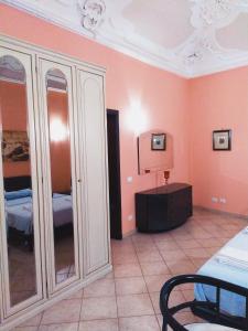 - une chambre aux murs roses avec un lit et un miroir dans l'établissement Apartment Basile, à Palerme