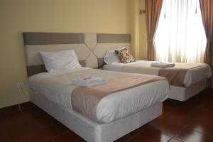 A bed or beds in a room at Hotel Casa Kolping Quito