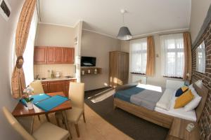 a bedroom with a bed and a table and a kitchen at Willa Idylla in Ustka