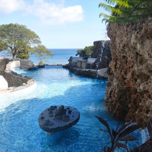 una piscina con agua azul y el océano en el fondo en Rockwater Resort en Isla de Tanna