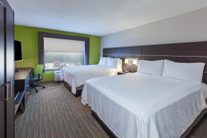 a hotel room with two beds and a desk and a window at Holiday Inn Express New Orleans East, an IHG Hotel in New Orleans