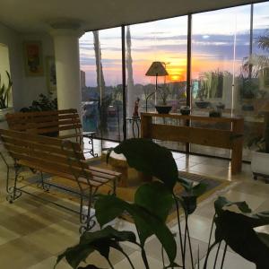 una sala de estar con bancos y vistas a la puesta de sol. en Hotel Faeli, en Matelândia