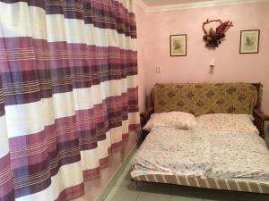 Habitación pequeña con cama y cortina en Emmy Apartman en Hajdúszoboszló