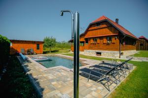 a house with a pool and a group of chairs at Kuća za odmor Balenović in Gospić