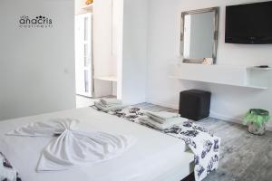 Cama blanca en habitación con espejo en Anacris Guesthouse en Costinesti