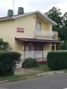 un piccolo edificio giallo con un cartello rosso di Emmy Apartman a Hajdúszoboszló