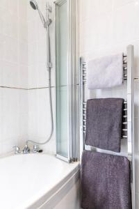 a bathroom with a shower and a bath tub with towels at SunnyBank in Denby Dale