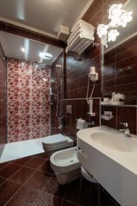 a bathroom with a toilet and a sink and a shower at Hotel Spessotto in Portogruaro
