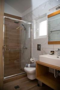 y baño con ducha, aseo y lavamanos. en Foxnest Rest Villa Corfu, en Kanálion