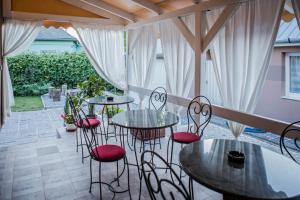a patio with tables and chairs on a patio at Virág Vendégház in Makó