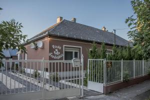 a small house with a fence in front of it at Virág Vendégház in Makó