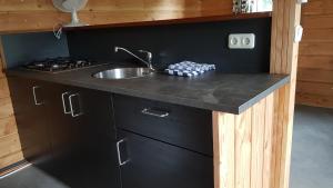 
a kitchen with a sink and a stove at Chalet - Camping 't Dekske in Wintelre
