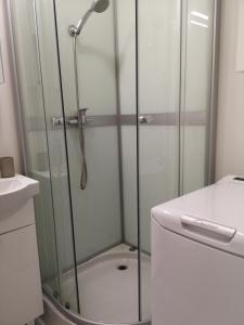 La salle de bains est pourvue d'une douche avec une porte en verre. dans l'établissement ONZ TOWER, à Varsovie