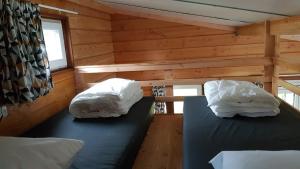 
two beds with pillows and blankets on top of them at Chalet - Camping 't Dekske in Wintelre
