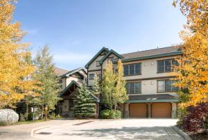 a large house with a driveway and trees at Corral at Breckenridge #102E - Access to Hot Tub - Close to Town in Breckenridge