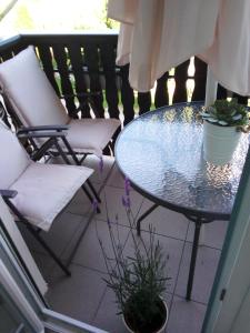 a glass table and two chairs on a balcony at Nika in Ogulin