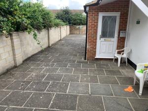 a patio with two chairs and a white door at Serviced Accommodations in Luton