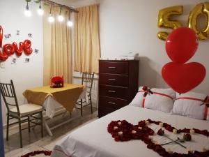 una camera con un letto con un cuore e un tavolo di Hotel Real Pólux a San Gil