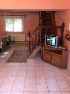 uma sala de estar com uma televisão e uma escada em Cabana MonteRio em Padis
