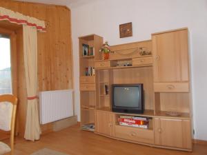 ein Wohnzimmer mit einem TV in einem hölzernen Unterhaltungszentrum in der Unterkunft Haus Waldruh in Niederau