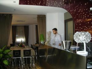 a man standing at a bar in a restaurant at Hotel de Meis in Capistrello