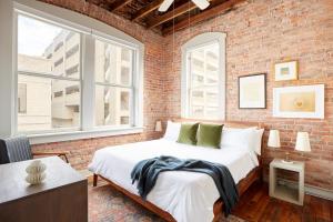 a bedroom with a bed and a brick wall at Sonder The Drayton in Savannah
