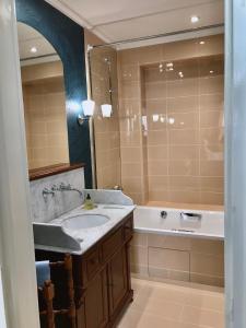 a bathroom with a sink and a bath tub at Le 48 Paris in Paris