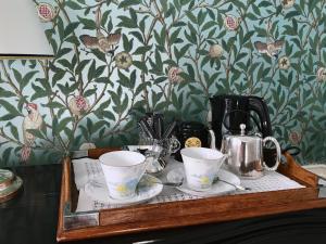 a tray with three cups and a tea kettle on it at Le 48 Paris in Paris