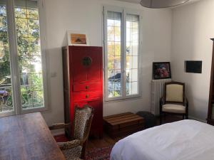 a bedroom with a red dresser next to a bed at Maison du bonheur in Villiers-sur-Marne