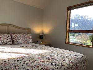 a bedroom with a bed and a large window at Visitor Rooms Prepay & Self Check in in Queenstown