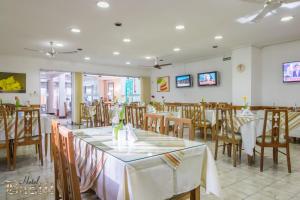 a dining room with tables and chairs in a restaurant at Hotel Bastit in Mar del Plata