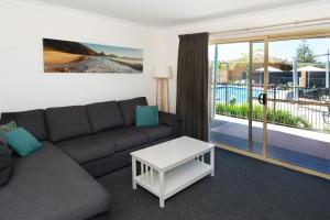a living room with a couch and a sliding glass door at Seaside Holiday Resort in Fingal Bay