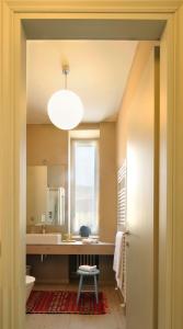 een badkamer met een wastafel, een toilet en een raam bij Sopra Il Posta in SantʼOmobono Imagna