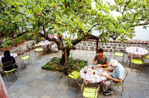 two men sitting at a picnic table under an umbrella at Guest House Old Plovdiv in Plovdiv