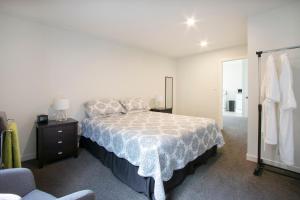 a bedroom with a bed and a dresser and a mirror at Hydrangea Cottage in Katikati