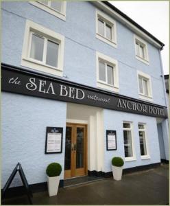 a blue building with a sign that reads the sea bird restaurant at Anchor Hotel and Seabed Restaurant in Tarbert