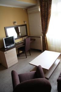 a living room with a desk and a mirror at Hotel Leotar in Trebinje