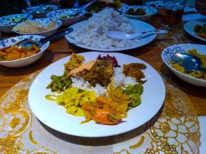 a table topped with plates of food and rice at Miheen Hotel & Resort - Anuradhapura in Mihintale