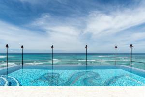 a swimming pool with the ocean in the background at ESPACIO THE JEWEL OF WAIKIKI in Honolulu