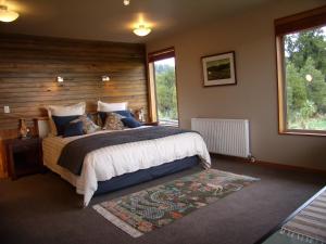 um quarto com uma cama grande e uma janela em Paramata Lodge em Kakapotahi