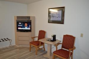 a living room with a table and chairs and a tv at Jolly Roger Hotel in Los Angeles