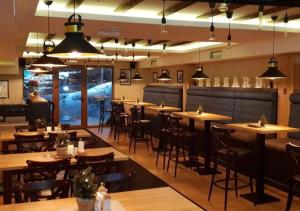 a restaurant with wooden tables and chairs and lights at Privat Studio Milmari in Kopaonik