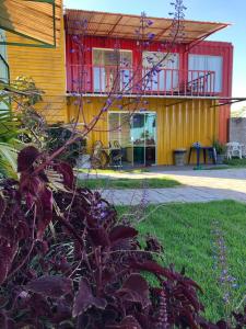 ein gelbes Gebäude mit rotem Dach in der Unterkunft Mandala House Container in Chapada dos Guimarães