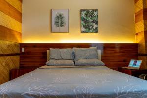 - un lit dans une chambre avec 2 photos sur le mur dans l'établissement Casa dela Playa (House by the Beach), à Dipolog