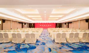 een lege banketzaal met witte tafels en stoelen bij Jin Jiang Pine City Hotel in Shanghai