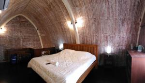 Bett in einem Zimmer mit Ziegelwand in der Unterkunft Sama Sama Bungalows in Gili Trawangan