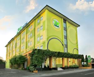 un edificio amarillo con un cartel. en Zest Yogyakarta by Swiss-Belhotel International en Yogyakarta