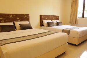 a hotel room with two beds and a window at Hotel Bandar Baru Menglembu in Ipoh +7 photos