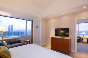 a hotel room with a bed and a flat screen tv at Kai Wah Plaza Hotel in Kunming