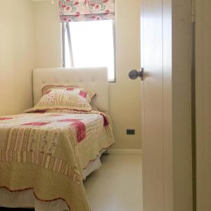 Depto Metro Santa Ana (2 dormitorios) في سانتياغو: غرفة نوم صغيرة بها سرير ونافذة